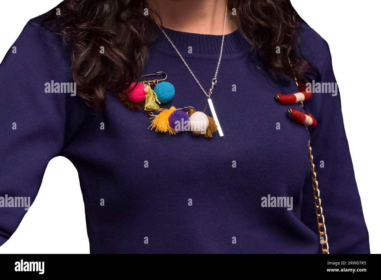 Women's dark purple sweater decorated with colored objects, soft toys on a pin, close-up on a white isolated background. Stock Photo
