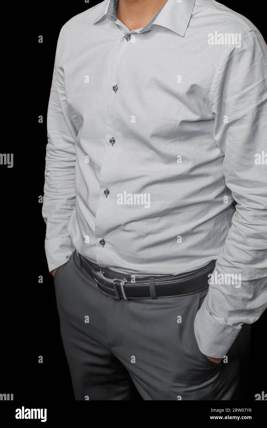 Men's business style clothing fashion white shirt on black background gray pants posing hands in pocket. Stock Photo