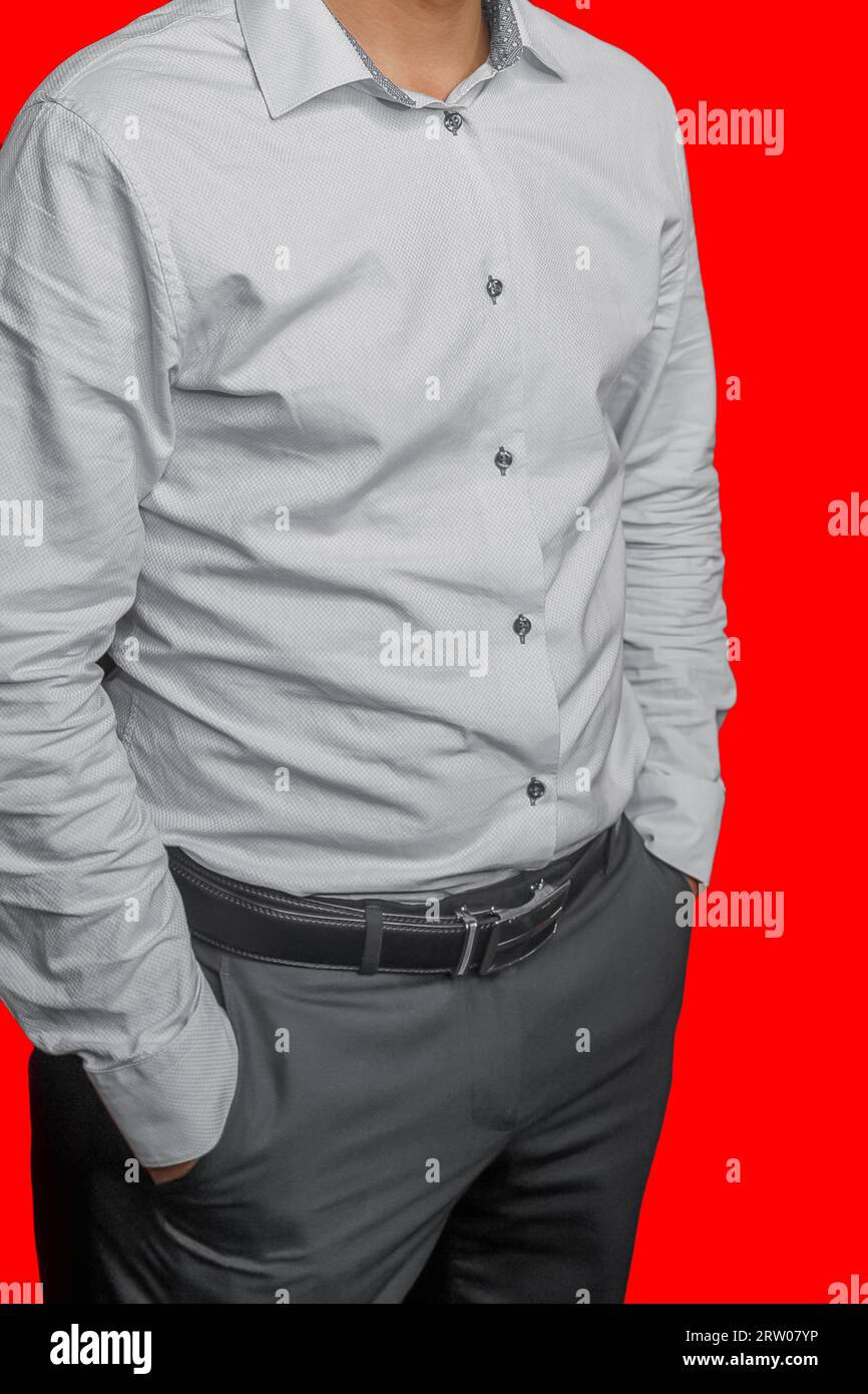Men's business style clothing fashion white shirt on red isolated background pants grey posing hands pocket. Stock Photo
