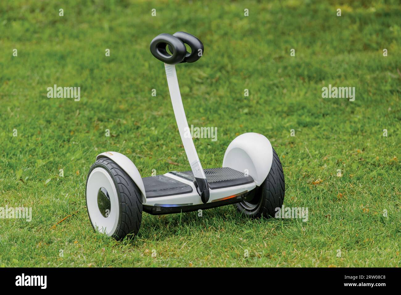 Hoverboard object is a street modern electric vehicle against the background of grass in the park. Stock Photo