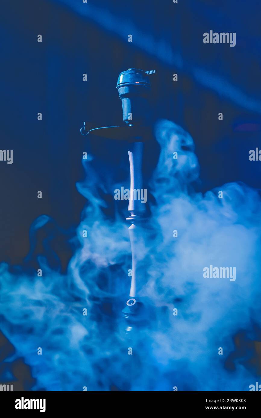 Hookah head, clay bowl and pipe, smoking object in smoke and blue light