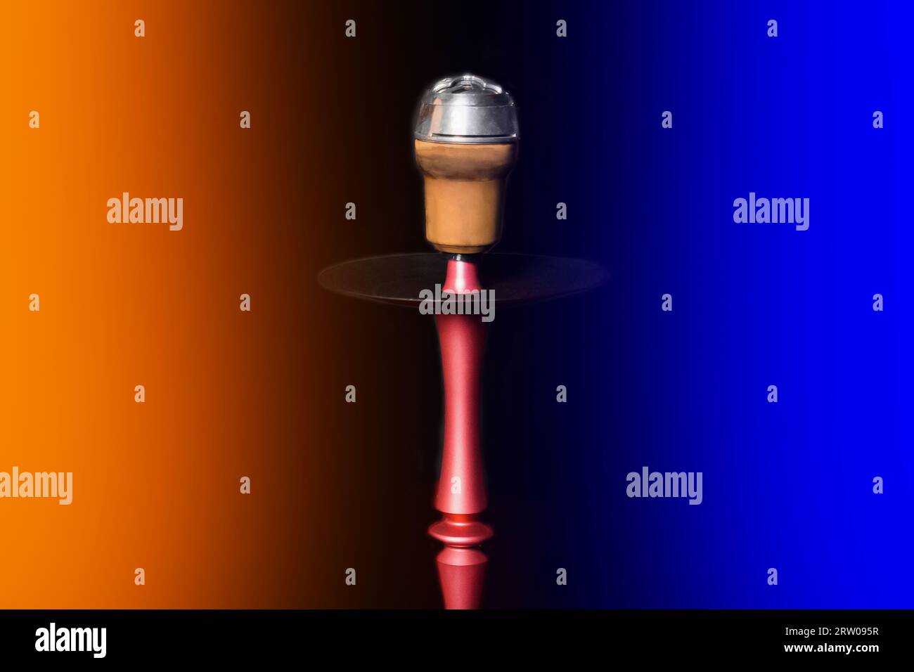 Clay object hookah head smoking on a black background in orange and blue neon light color Stock