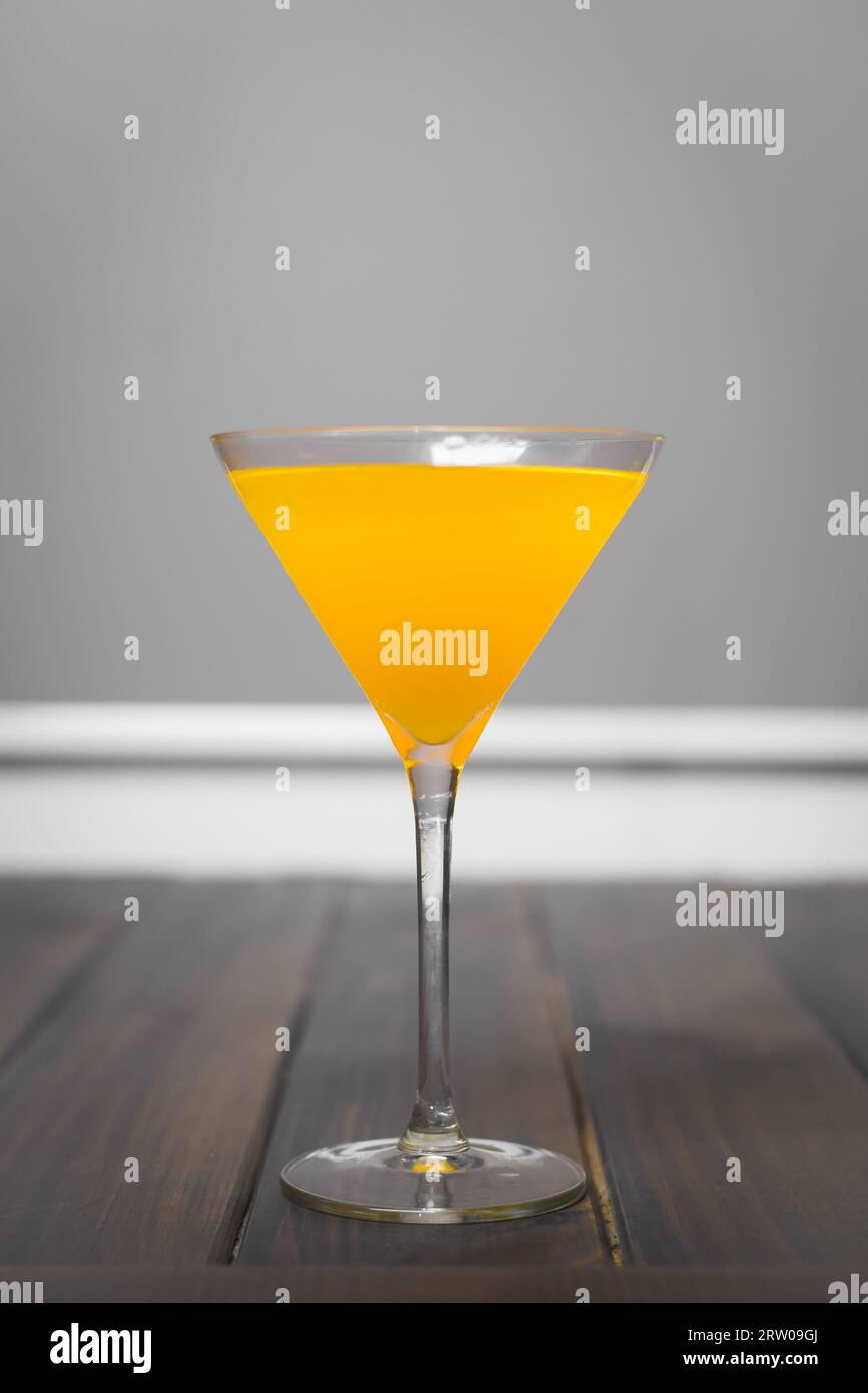 A martini glass with a yellow alcoholic beverage alco drink. Stock Photo