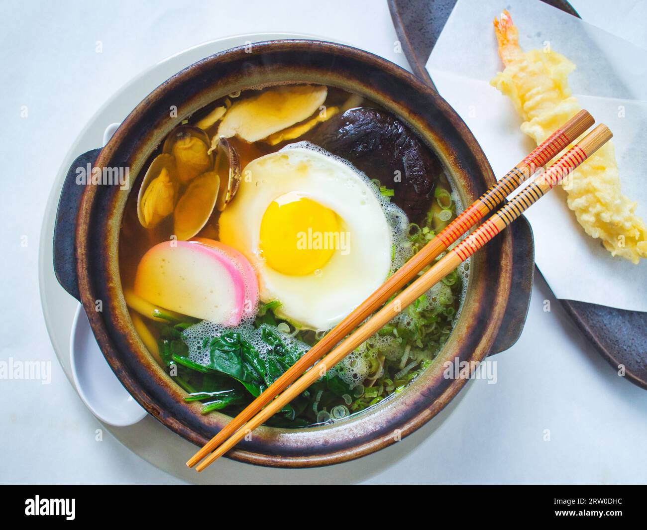 Top view of nabeyaki udon, Japanese soup with chopsticks. Stock Photo