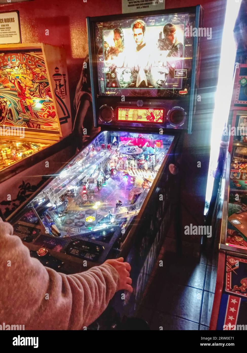 Someone playing on a pinball machine (NC State, 2023) Stock Photo