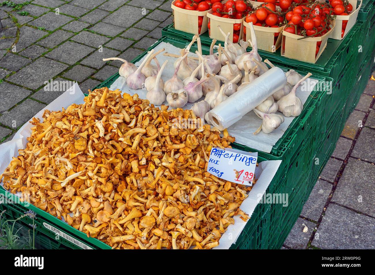 Market stall with real chanterelles (Cantharellus cibarius), garlic (Allium sativum), and tomatoes (Solanum lycopersicum), Kempten, Allgaeu, Bavaria Stock Photo