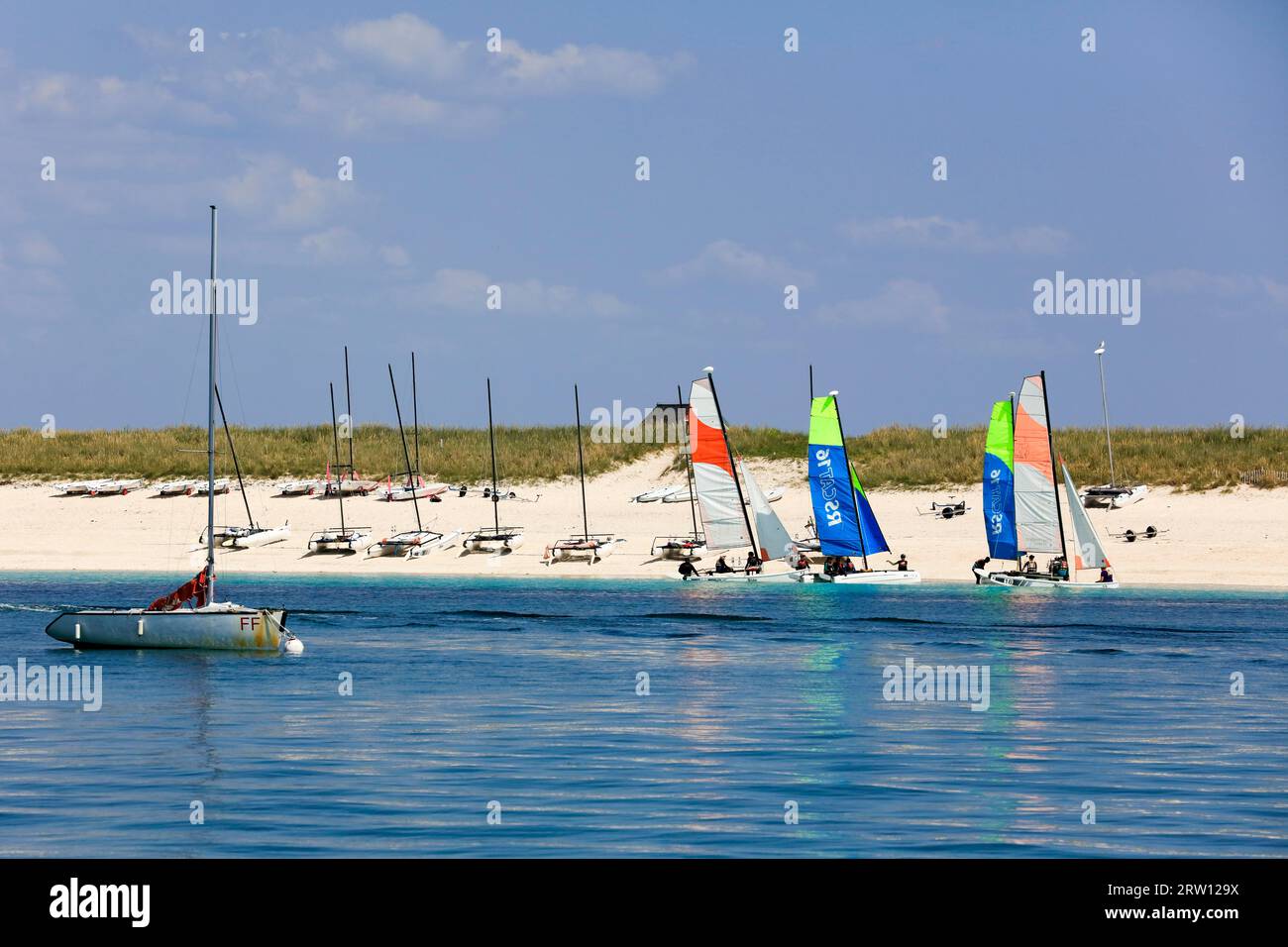 Sandy beach beach of the island Ile de Penfret with catamarans of the sailing school Les Glenans, Glenan Islands, archipelago of the Glenan in the Stock Photo