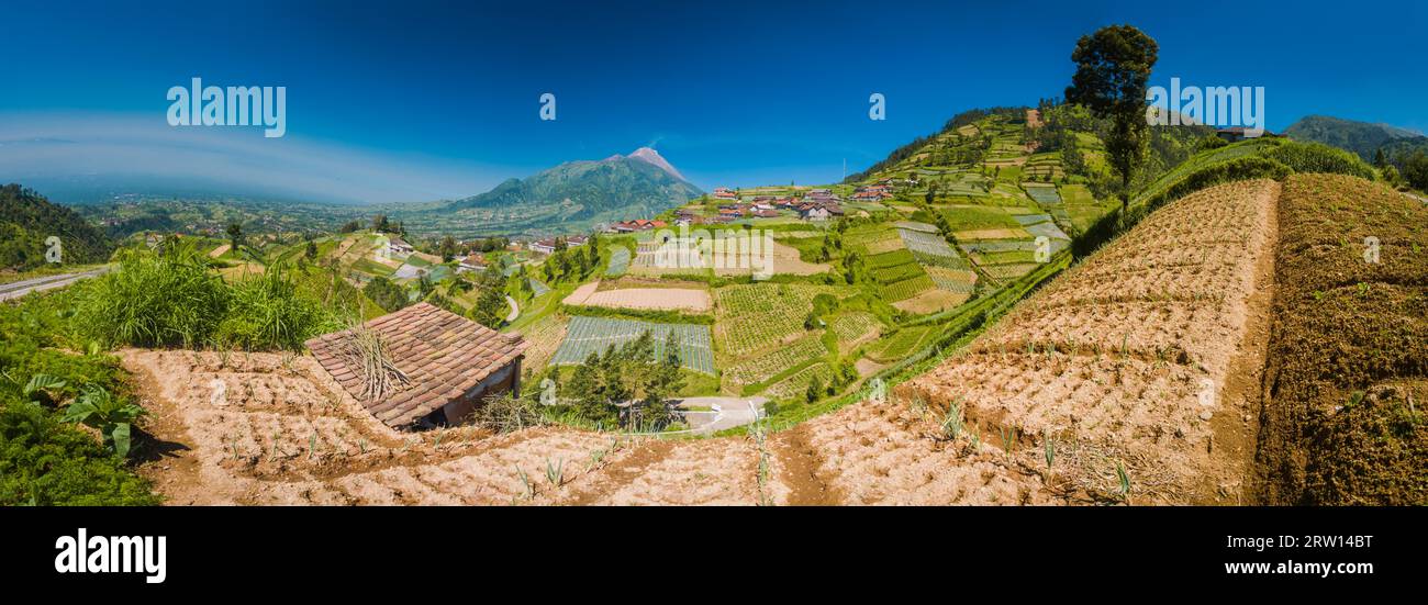 Panoramic photo of village and houses with Mount Merbabu in distance near Yogya in central Java province in Indonesia. In this region, one can only Stock Photo
