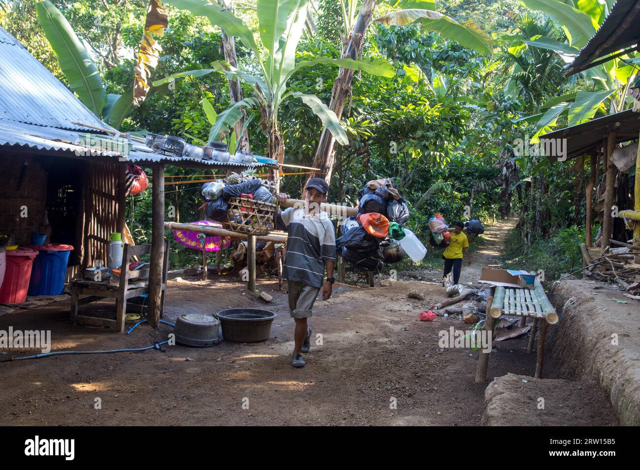 Lombok, Indonesia, July 14, 2015: Two porters carrying goods on the way ...