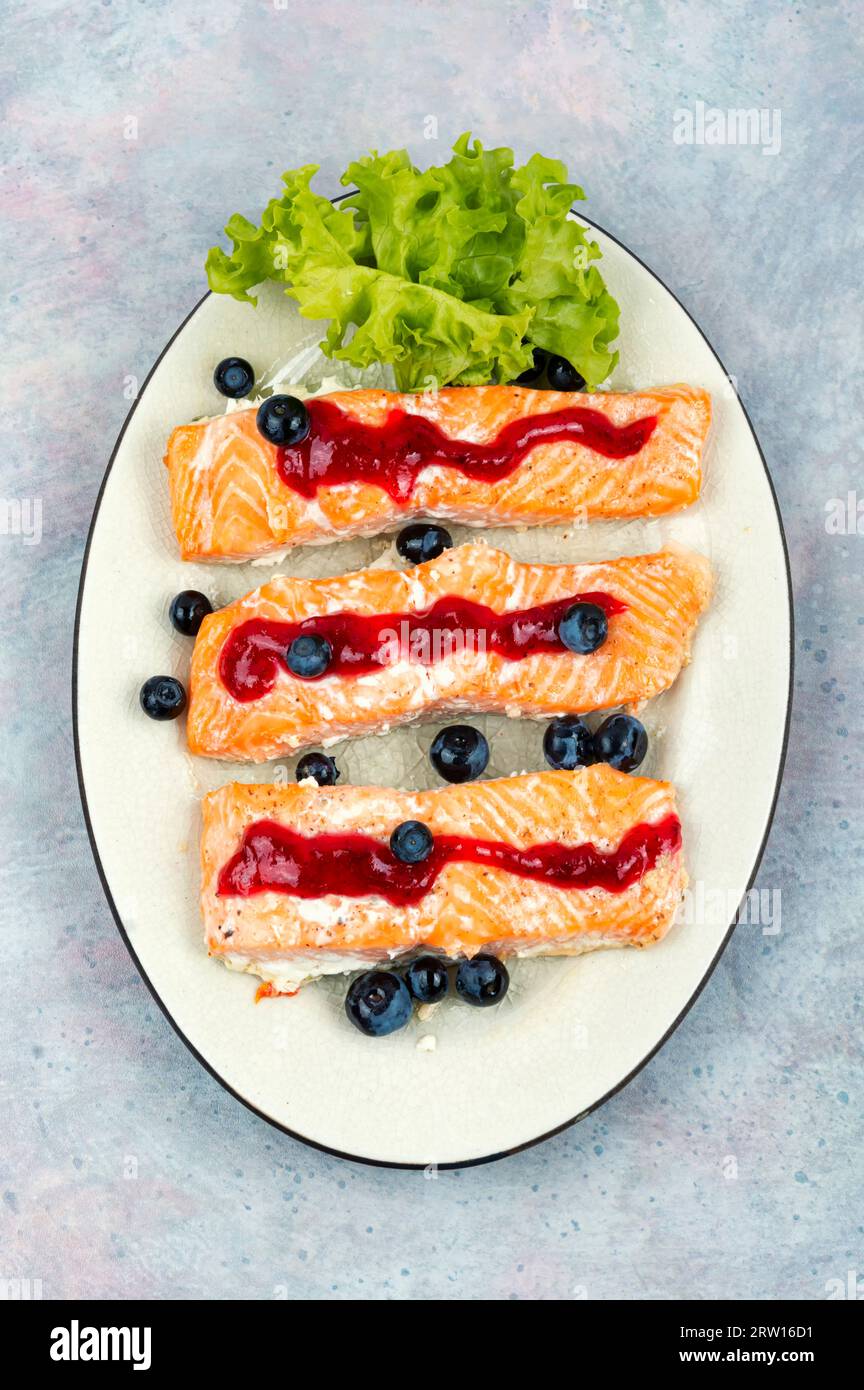 Baked salmon fillet with blueberry berry sauce. Top view Stock Photo