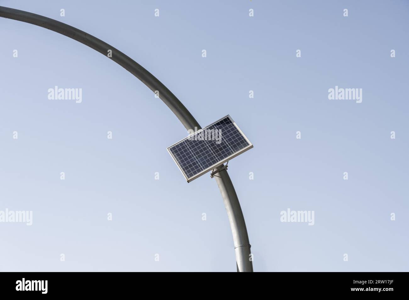 A photoelectric cell charging device on a curved metal pole Stock Photo