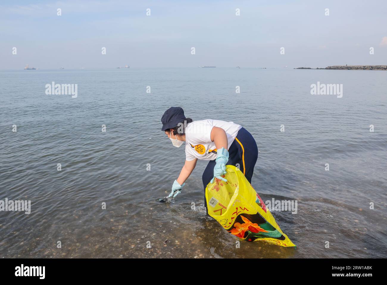 Manila, Philippines. 16th Sep, 2023. A volunteer collects rubbish during an activity to mark the International Coastal Cleanup Day along the coast of Manila Bay in Manila, the Philippines, Sept. 16, 2023. The International Coastal Cleanup Day is celebrated annually on the third Saturday in September, urging people around the world to remove trash and rubbish from all seasides and waterways to reduce the effect of plastic pollution on marine animals. Credit: Rouelle Umali/Xinhua/Alamy Live News Stock Photo