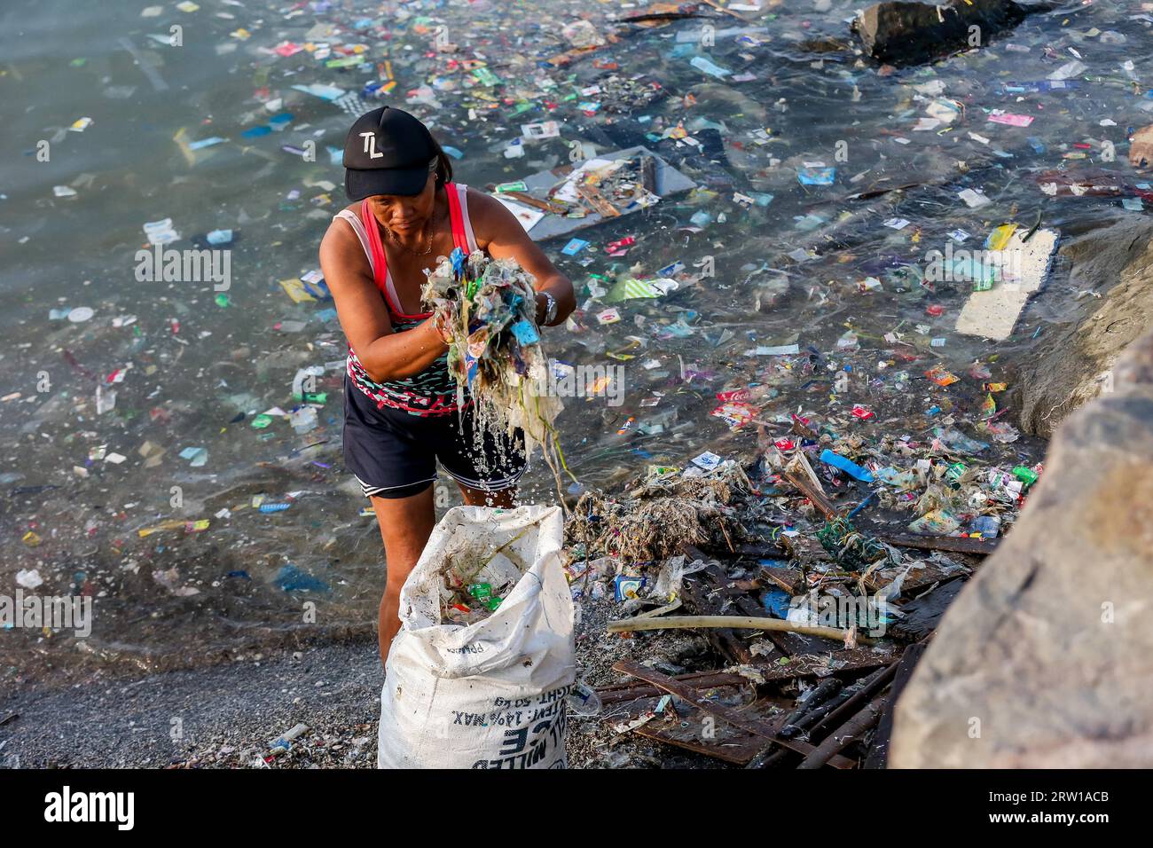 Manila, Philippines. 16th Sep, 2023. A volunteer collects rubbish during an activity to mark the International Coastal Cleanup Day along the coast of Manila Bay in Manila, the Philippines, Sept. 16, 2023. The International Coastal Cleanup Day is celebrated annually on the third Saturday in September, urging people around the world to remove trash and rubbish from all seasides and waterways to reduce the effect of plastic pollution on marine animals. Credit: Rouelle Umali/Xinhua/Alamy Live News Stock Photo