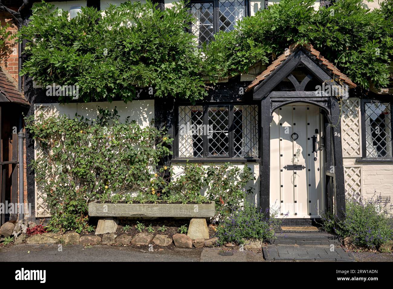 Country cottage England. Black and white timbered with leaded windows, UK traditional home Stock Photo