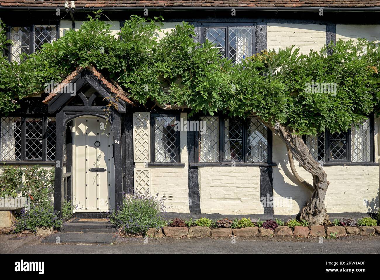 Country cottage England. Black and white timbered with leaded windows, UK traditional home Stock Photo