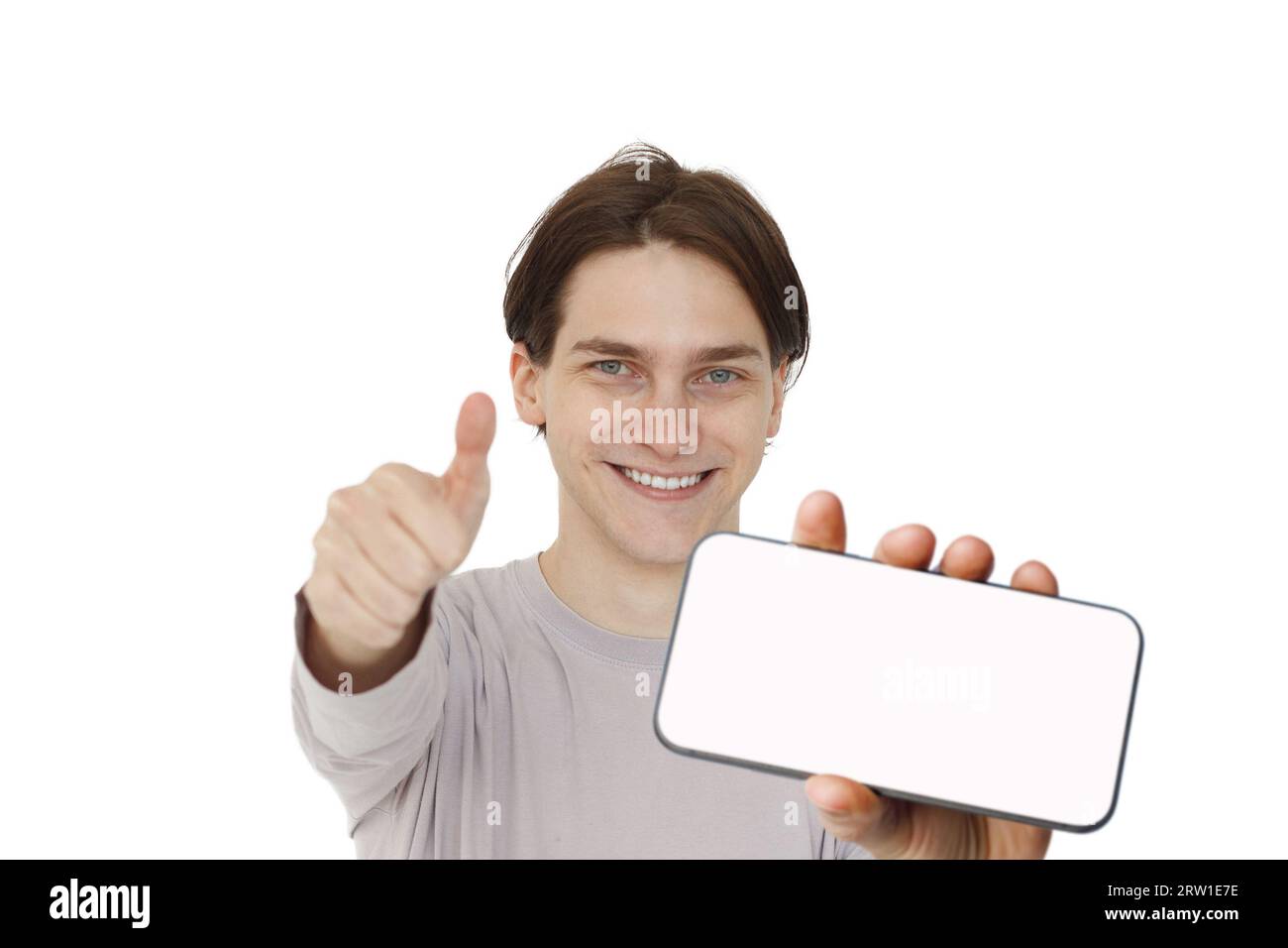 Happy guy holding smartphone in horizontal position with empty blank screen. Handsome young man playing game, surfing online or learning. Mockup phone Stock Photo