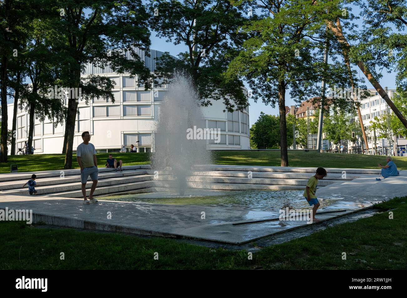 08.07.2023, Germany, North Rhine-Westphalia, Bielefeld - Fountain in a park in the city centre, in the back Stadthalle Bielefeld. 00A230708D029CAROEX. Stock Photo