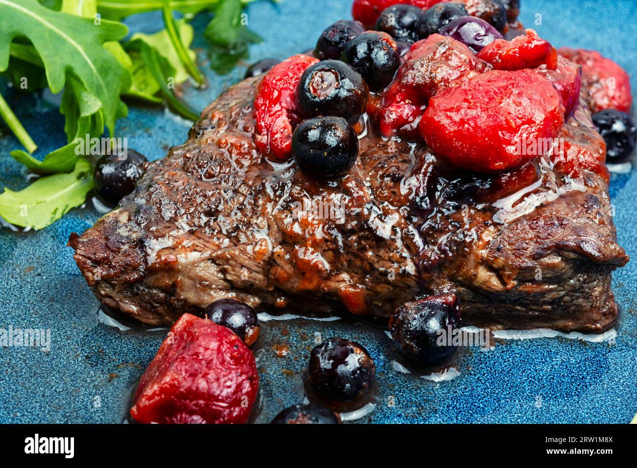 Delicious grilled meat medallions with berries sauce. Close up. Stock Photo