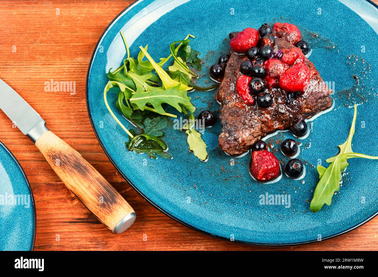 Fried beef fillet medallion steak with berry sauce on the table