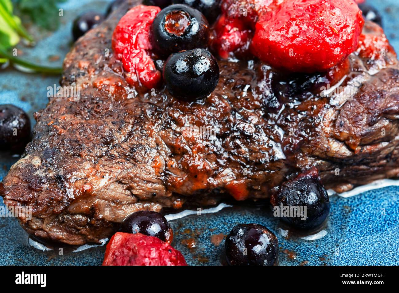 Delicious grilled meat medallions with berries sauce. Close up. Stock Photo