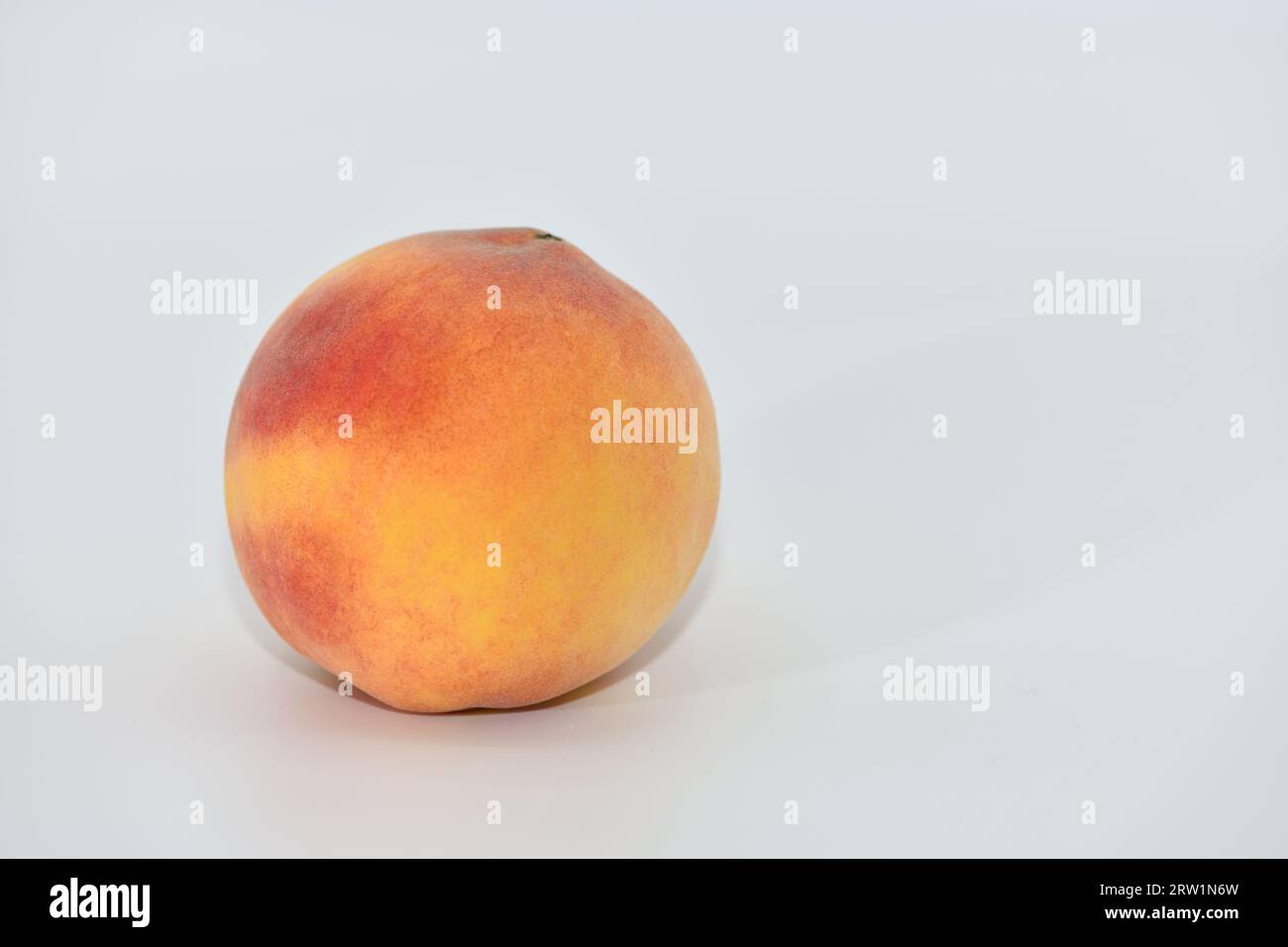 Peaches stacked in three on a white background. Stock Photo