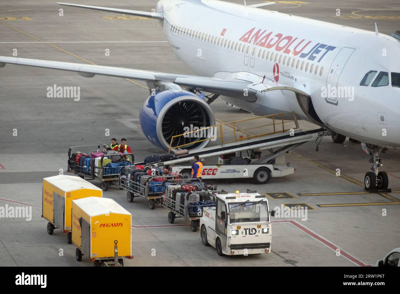 21.03.2023, Turkey, Istanbul, Istanbul - Suitcase trolleys in front of an Anadolujet aircraft on the apron of Istanbul Sabiha Goekcen Airport. 00S2303 Stock Photo