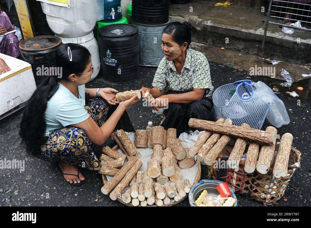 01.08.2013, Myanmar, Yangon, Yangon - A daily market scene shows a woman buying thanaka wood at a street market in the city centre to make a paste for Stock Photo