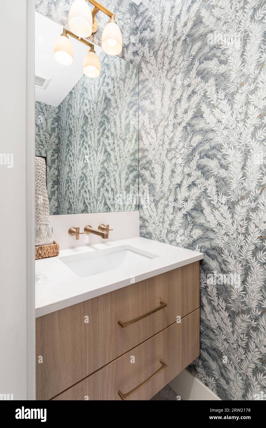 A bathroom with floral wallpaper, a floating wood vanity cabinet ...