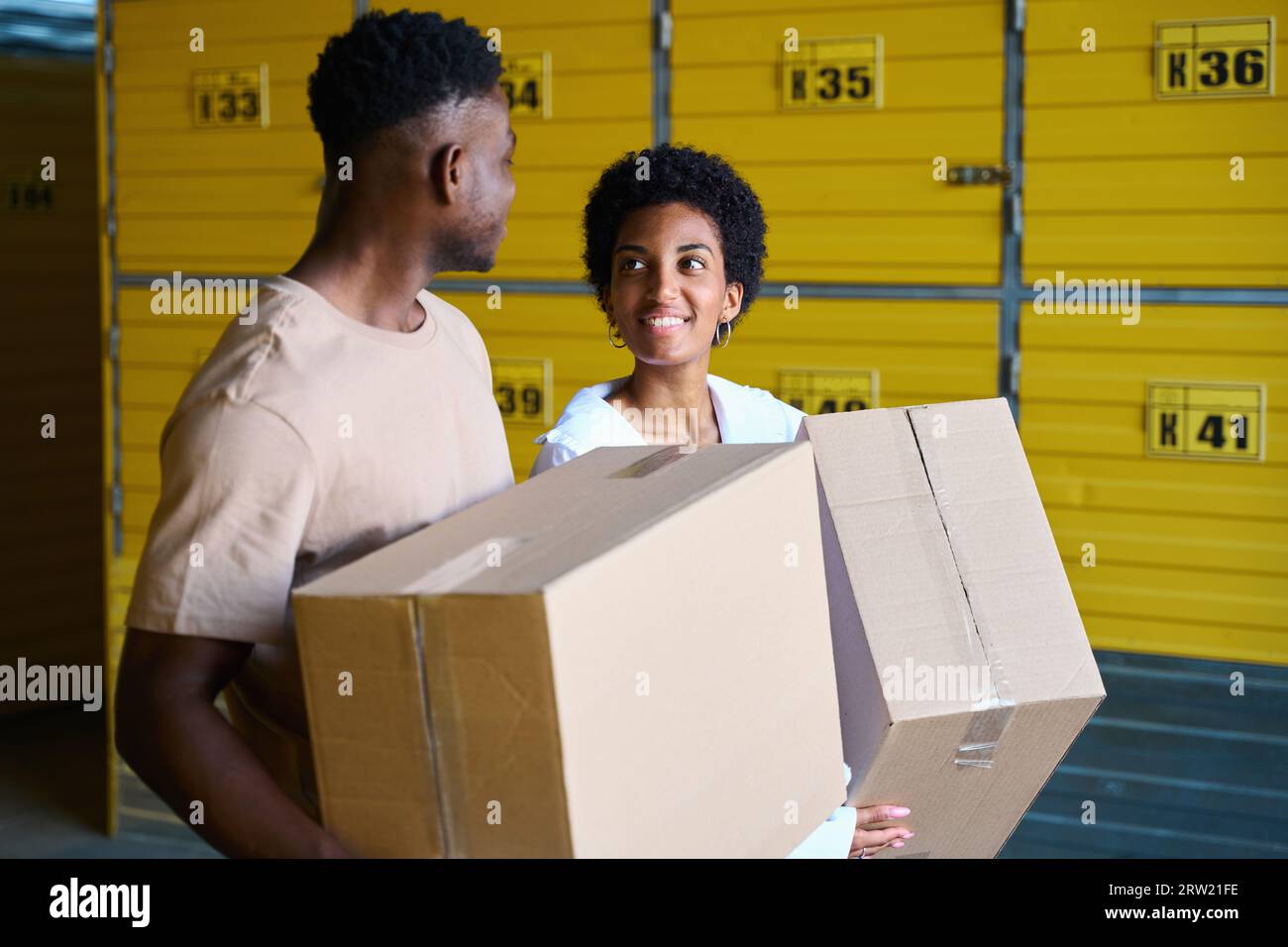 African American guys in warehouse with cardboard boxes in their hands ...