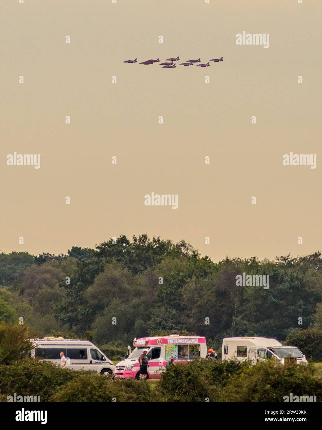 Stoney Cross, New Forest, Hampshire, UK, 16th September 2023, Weather: An overcast and humid day with the RAF Red Arrows display team crossing a grey sky after performing a flypast for Ringwood carnival. Paul Biggins/Alamy Live News Stock Photo