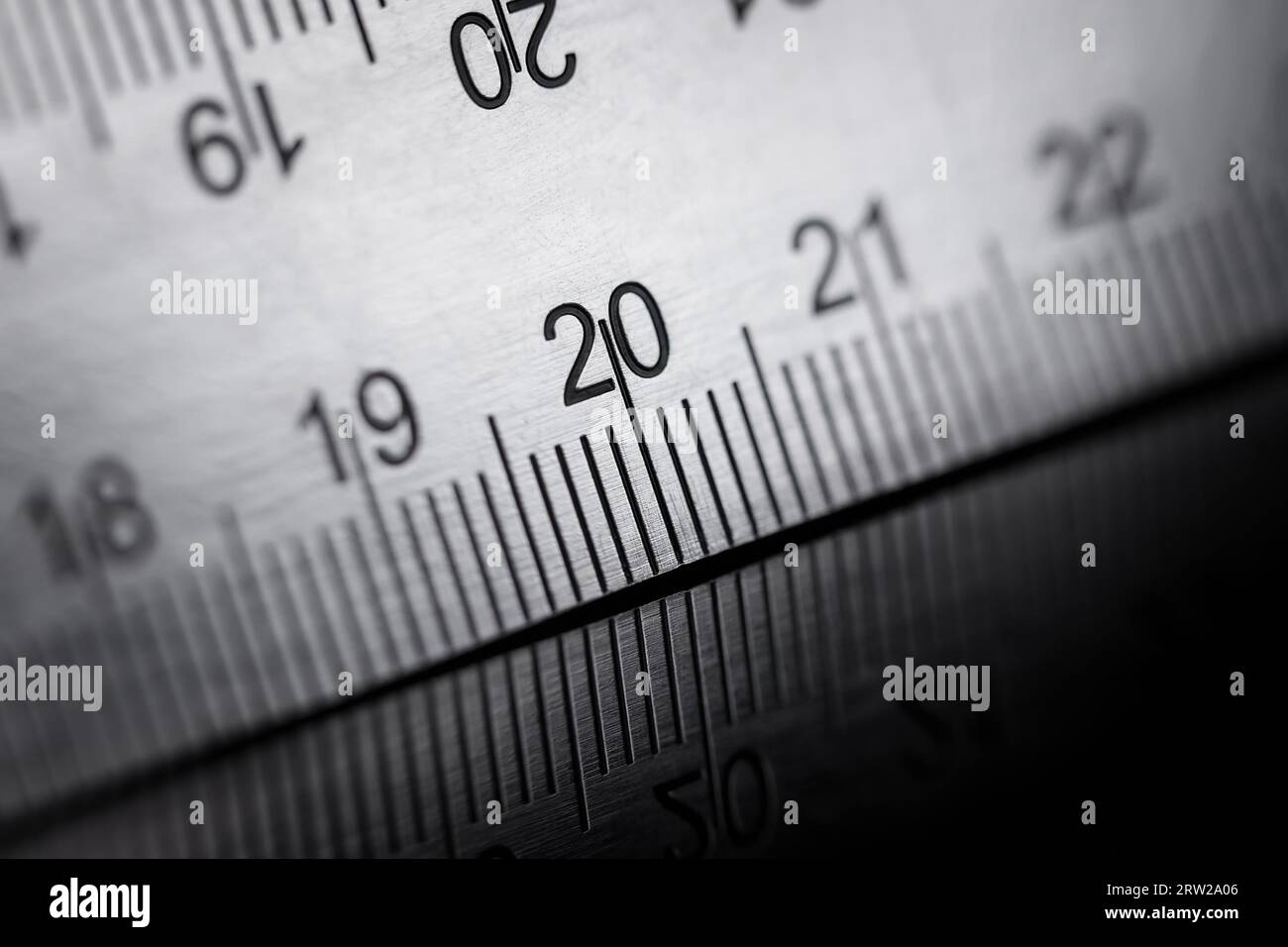 Metal ruler with shallow depth of field, reflection. Macro photography. Stock Photo