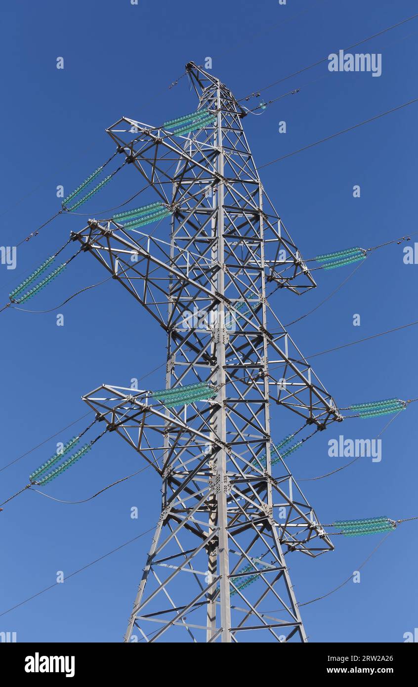 High pylon of a power line against the blue sky Stock Photo