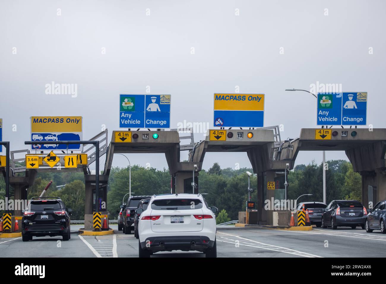 A Car enters a Toll Plaza. MACPASS banner at a Toll Plaza. MAC PASS is electronic tolling system for Halifax Harbour Bridges HHB. HALIFAX, NOVA SCOTIA Stock Photo