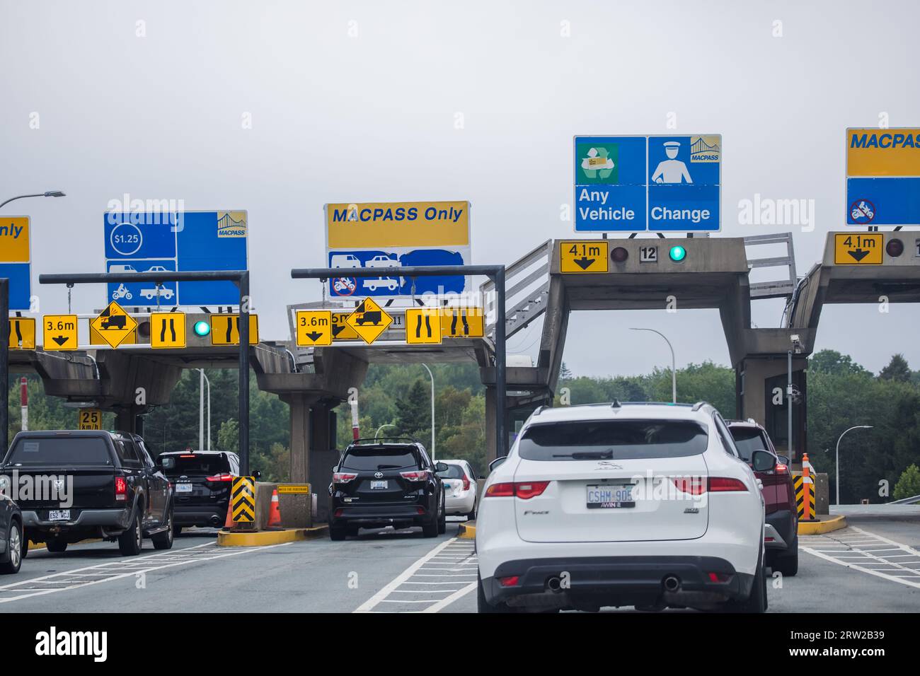 A Car enters a Toll Plaza. MACPASS banner at a Toll Plaza. MAC PASS is electronic tolling system for Halifax Harbour Bridges HHB. HALIFAX, NOVA SCOTIA Stock Photo