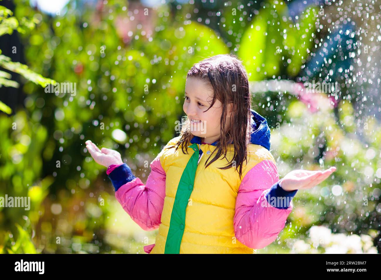Child playing in autumn rain. Kid with umbrella. Little girl running in