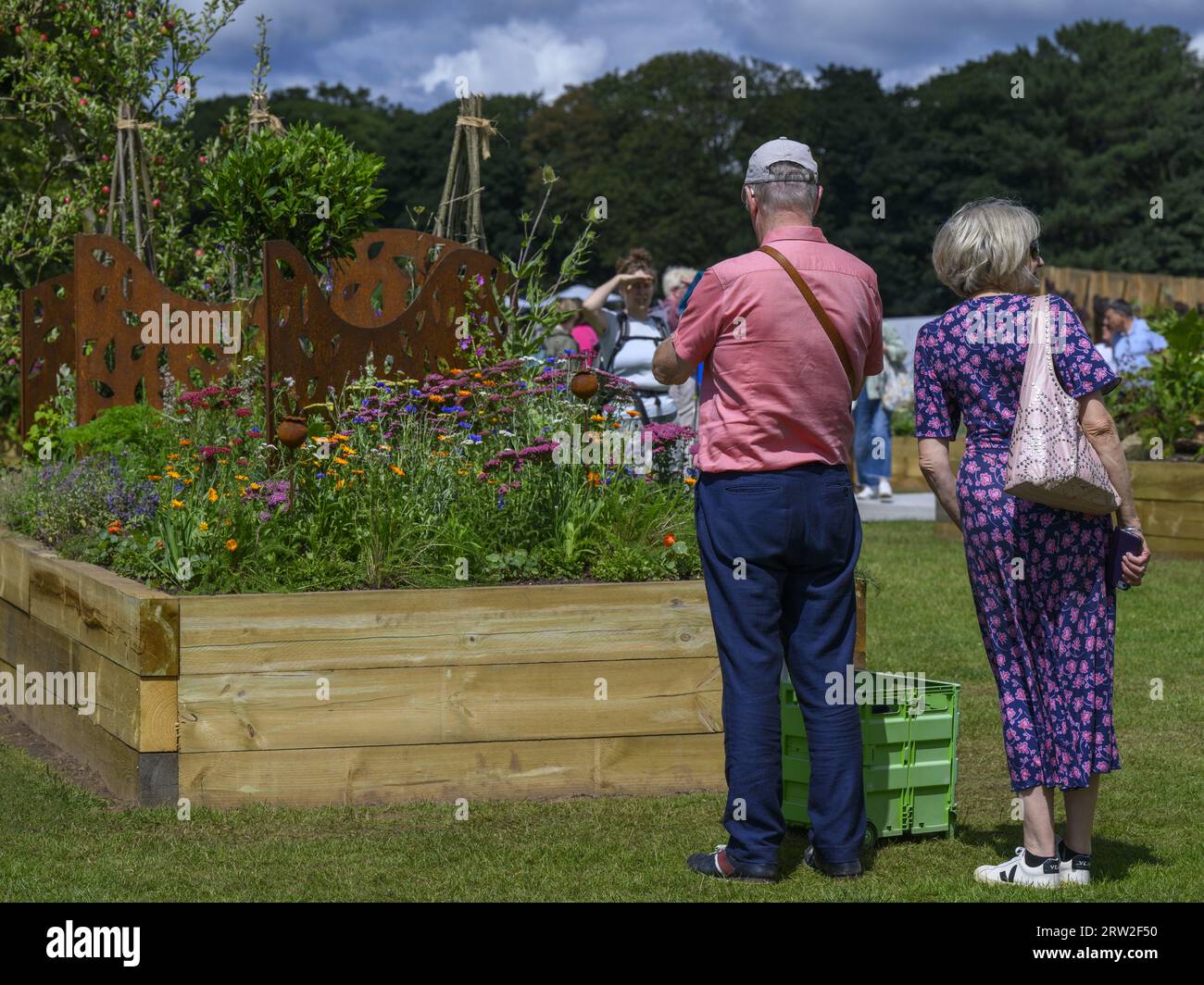 Visitors view colourful garden flowers - horticultural raised bed competition entry, RHS Tatton Park Flower Show 2023 showground, Cheshire England UK. Stock Photo