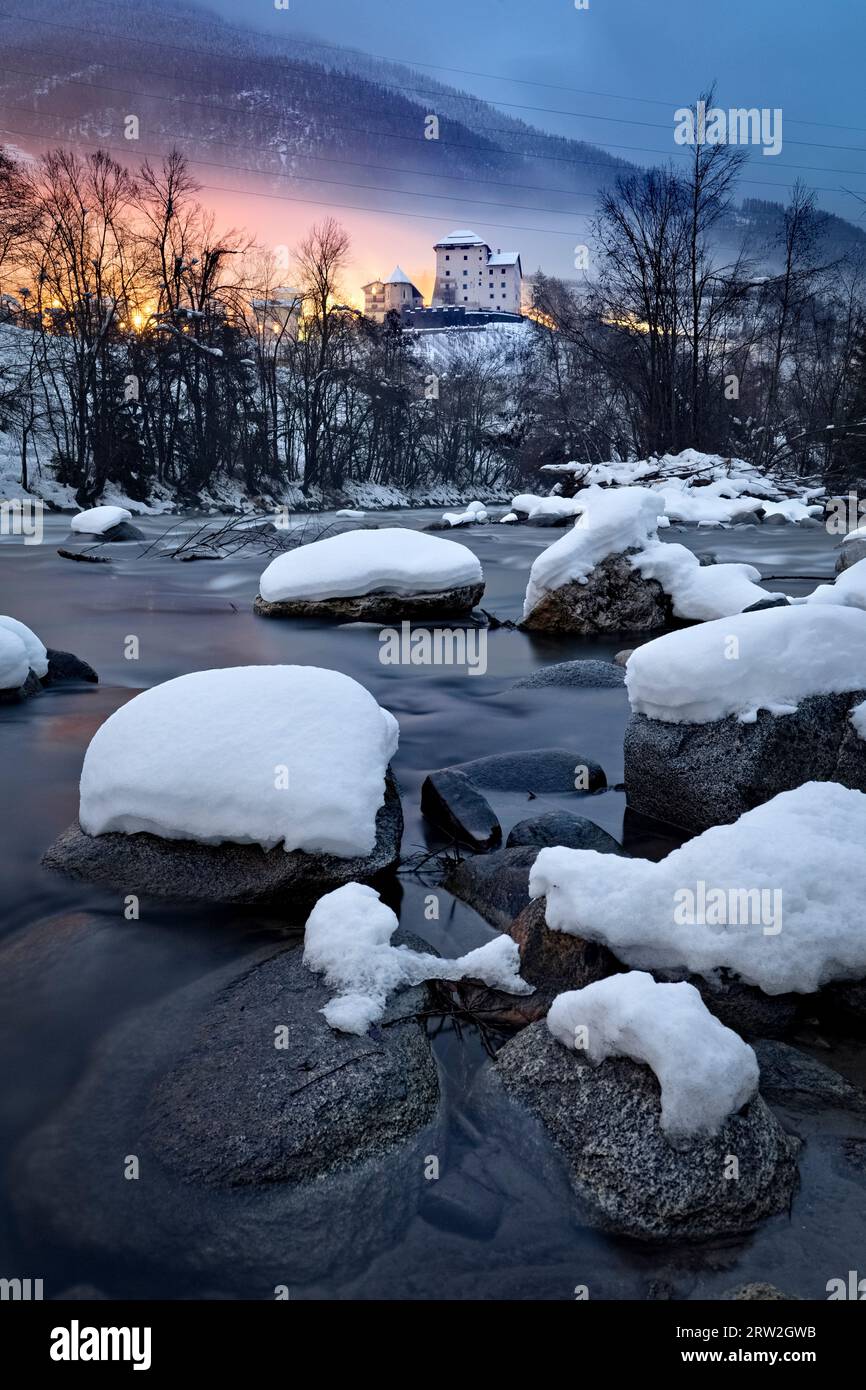 The Noce stream and the medieval castle of Caldes on a winter night