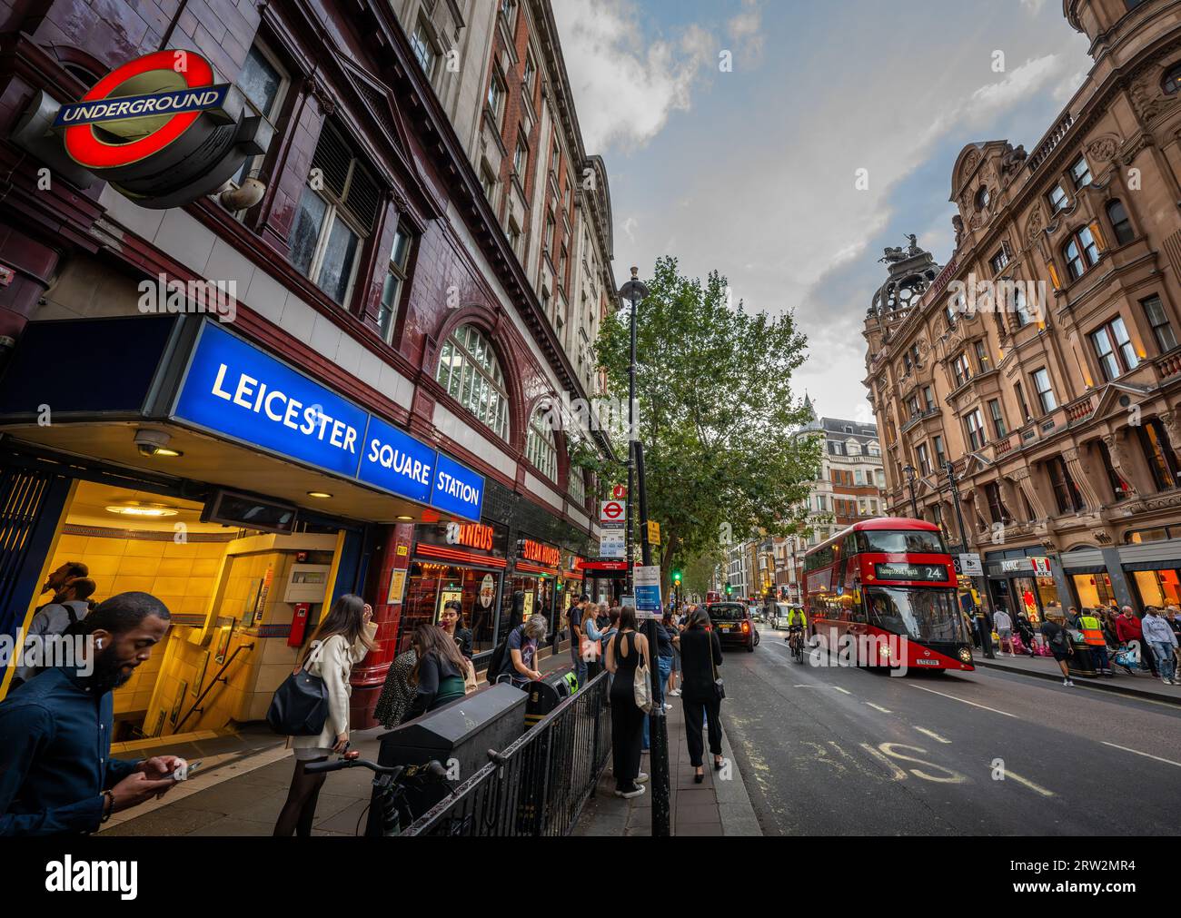 London, UK: Leicester Square underground station on Charing Cross Road located in London's West End. With red London bus. Stock Photo