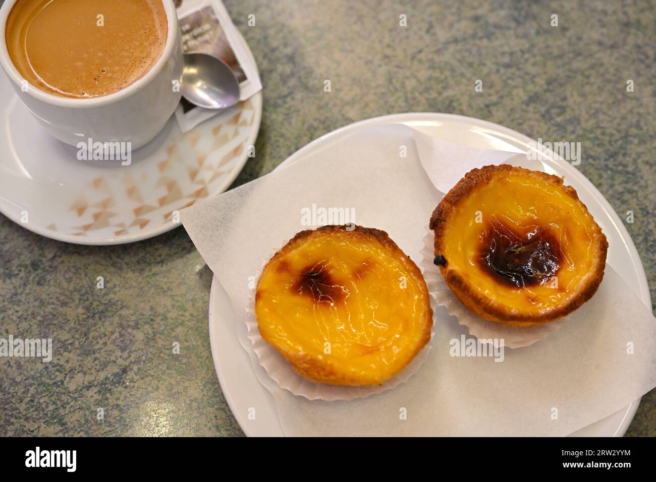 Two traditional Portuguese egg tart pastries, Pastel de Nata, with cup of coffee Stock Photo