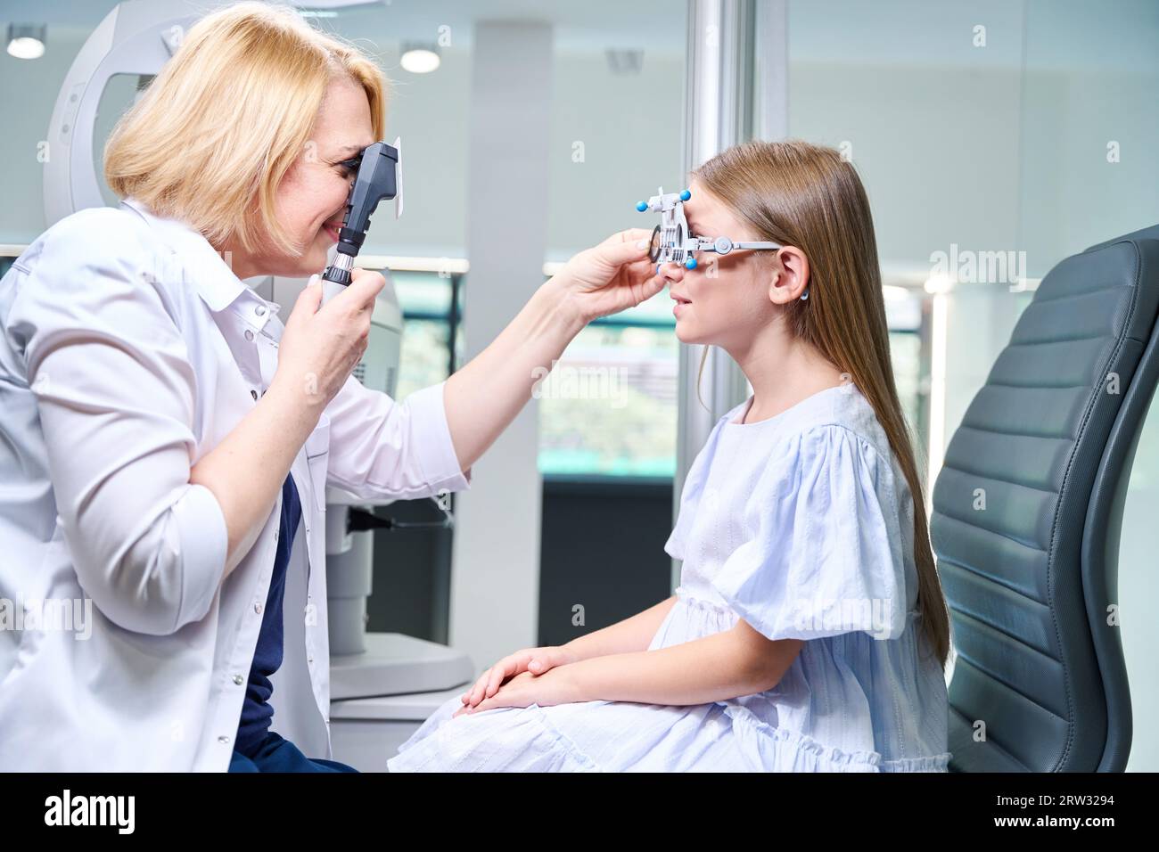 Focused eye doctor conducting dynamic retinoscopy on pediatric patient