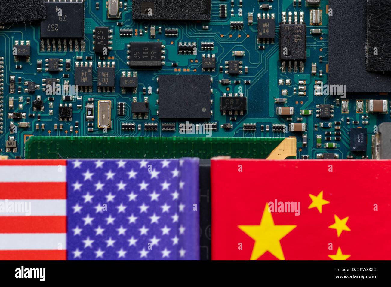 A technology conflict, competition concept with the American and Chinese flags on top of a semiconductor circuit board. Stock Photo