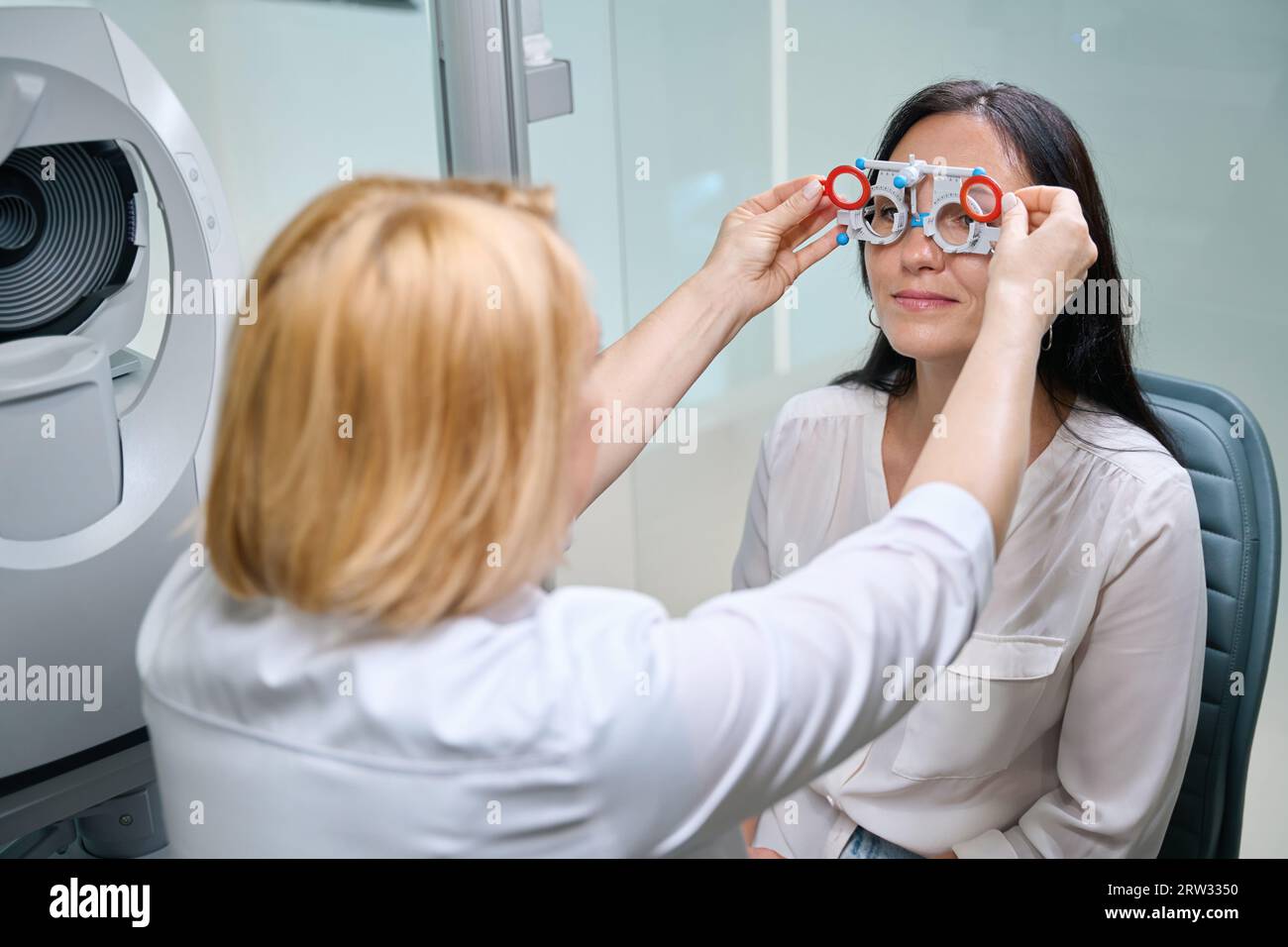 Optometrist performing binocular subjective refraction on female