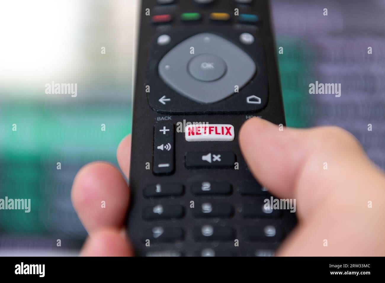London. UK- 09.13.2023. A person using the remote control to access the popular streaming entertainment service provider Netflix. Stock Photo