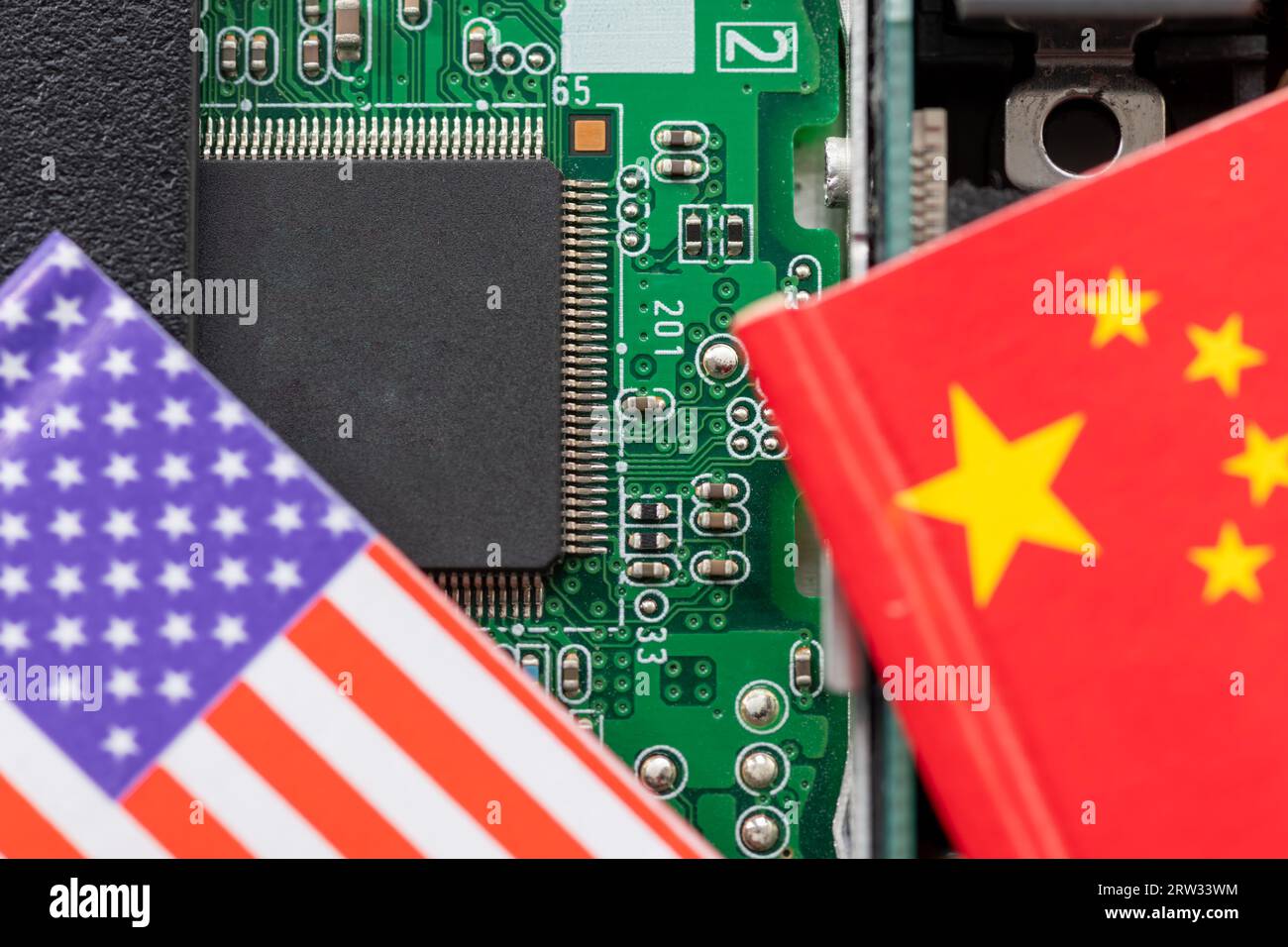 A technology conflict, competition concept with the American and Chinese flags on top of a semiconductor circuit board. Stock Photo