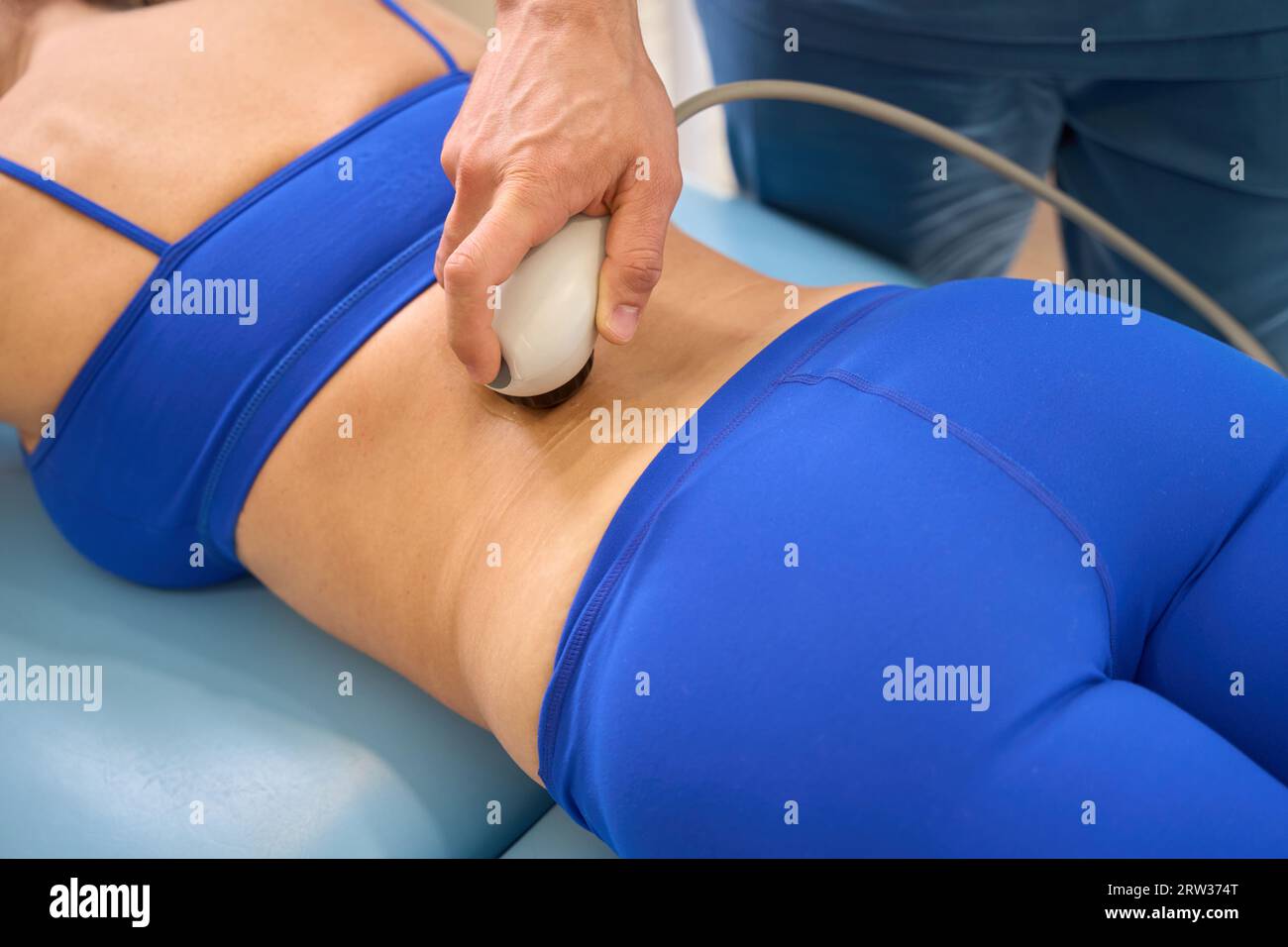 Physiotherapist performing the procedure of cavitation, removing adipose tissue Stock Photo