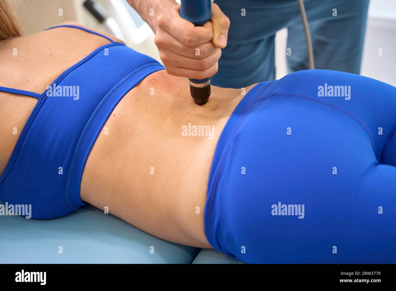 Qualified physiotherapist conducting extracorporeal shockwave therapy Stock Photo