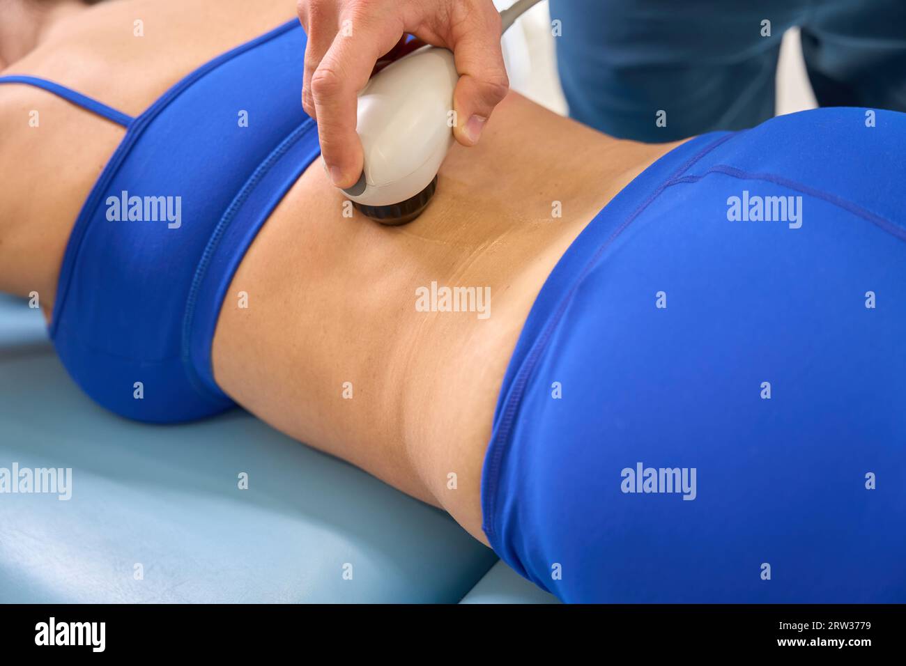 Skilled manual therapist performing extracorporeal shock wave therapy Stock Photo