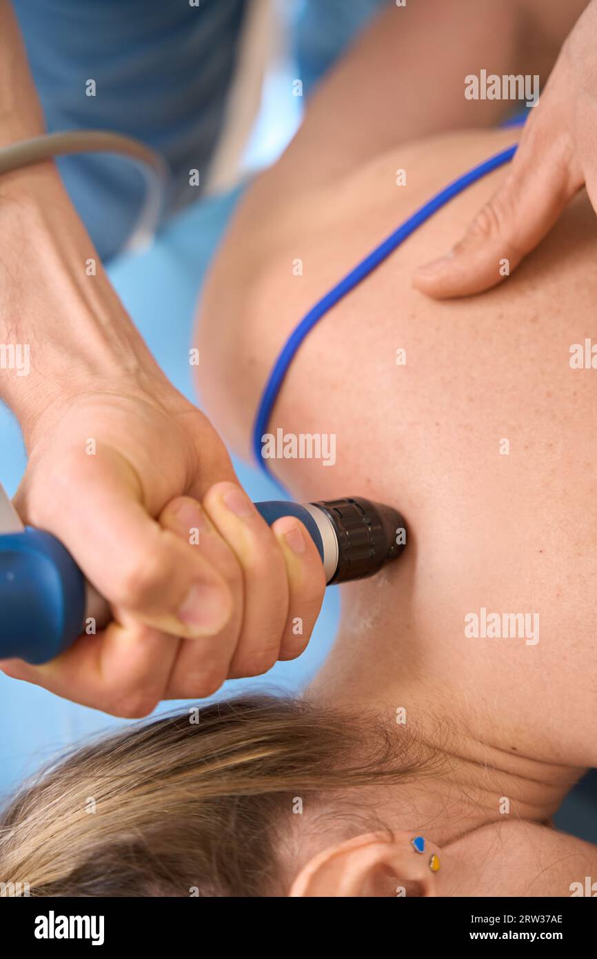 Male therapist affecting on trigger point on female shoulders Stock Photo