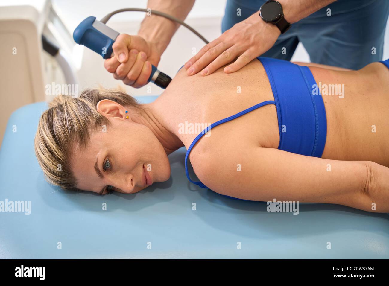 Male doctor making trigger point therapy to woman on massage couch Stock Photo