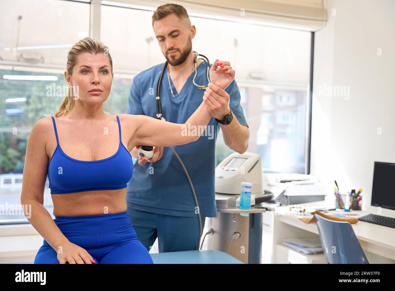 Physiotherapist performing extracorporeal shock wave therapy Stock Photo